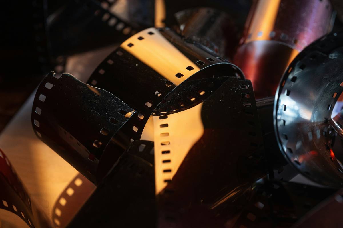 Cinematographer inspecting film reels with negative film insurance documentation nearby