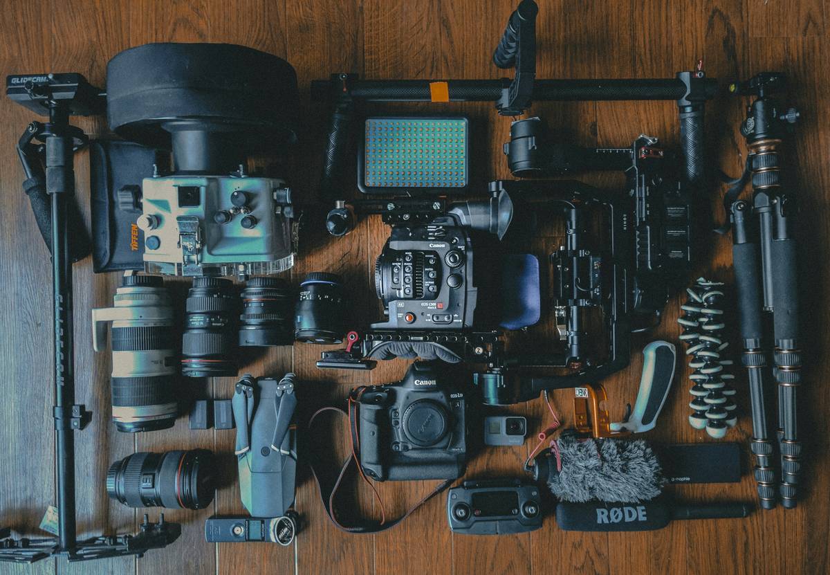 Cinematographer inspecting damaged camera gear with rental equipment insurance documentation nearby